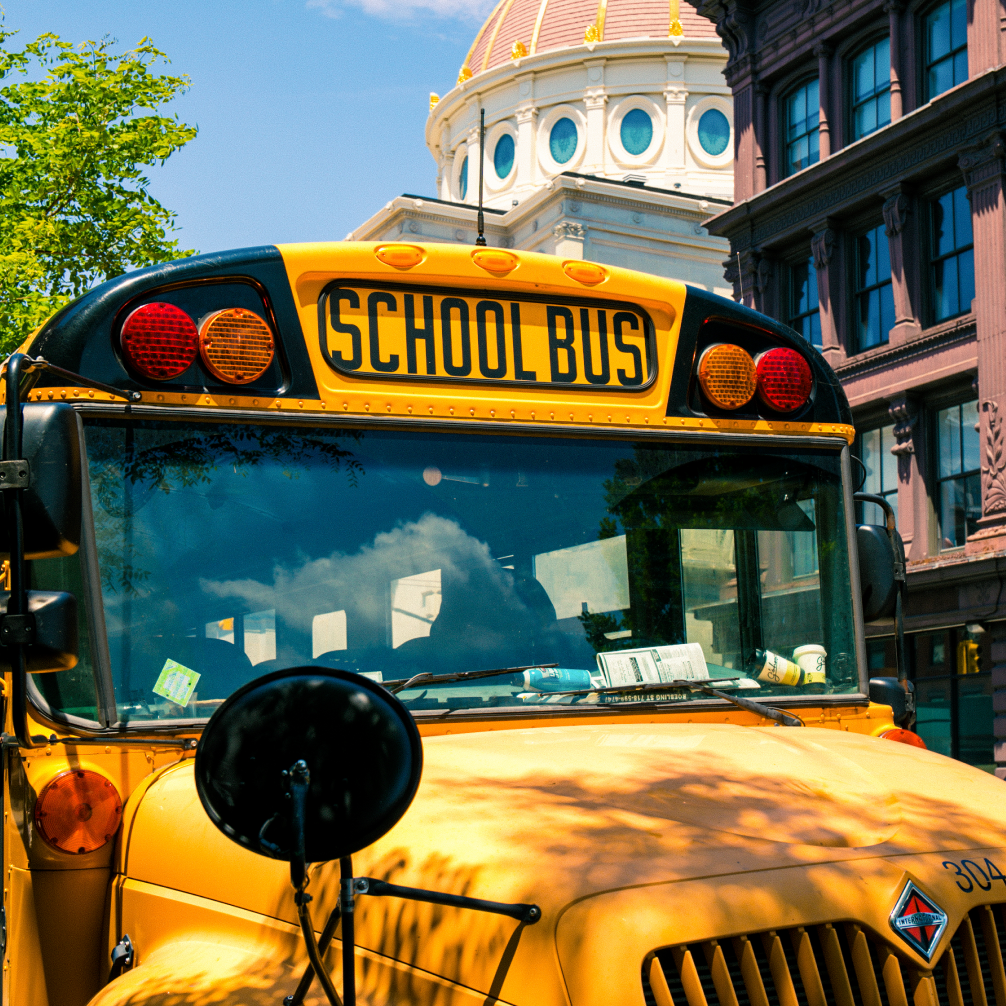 A photography of a busy city, taken from an overpass, looking across to buildings and a road through the centre.