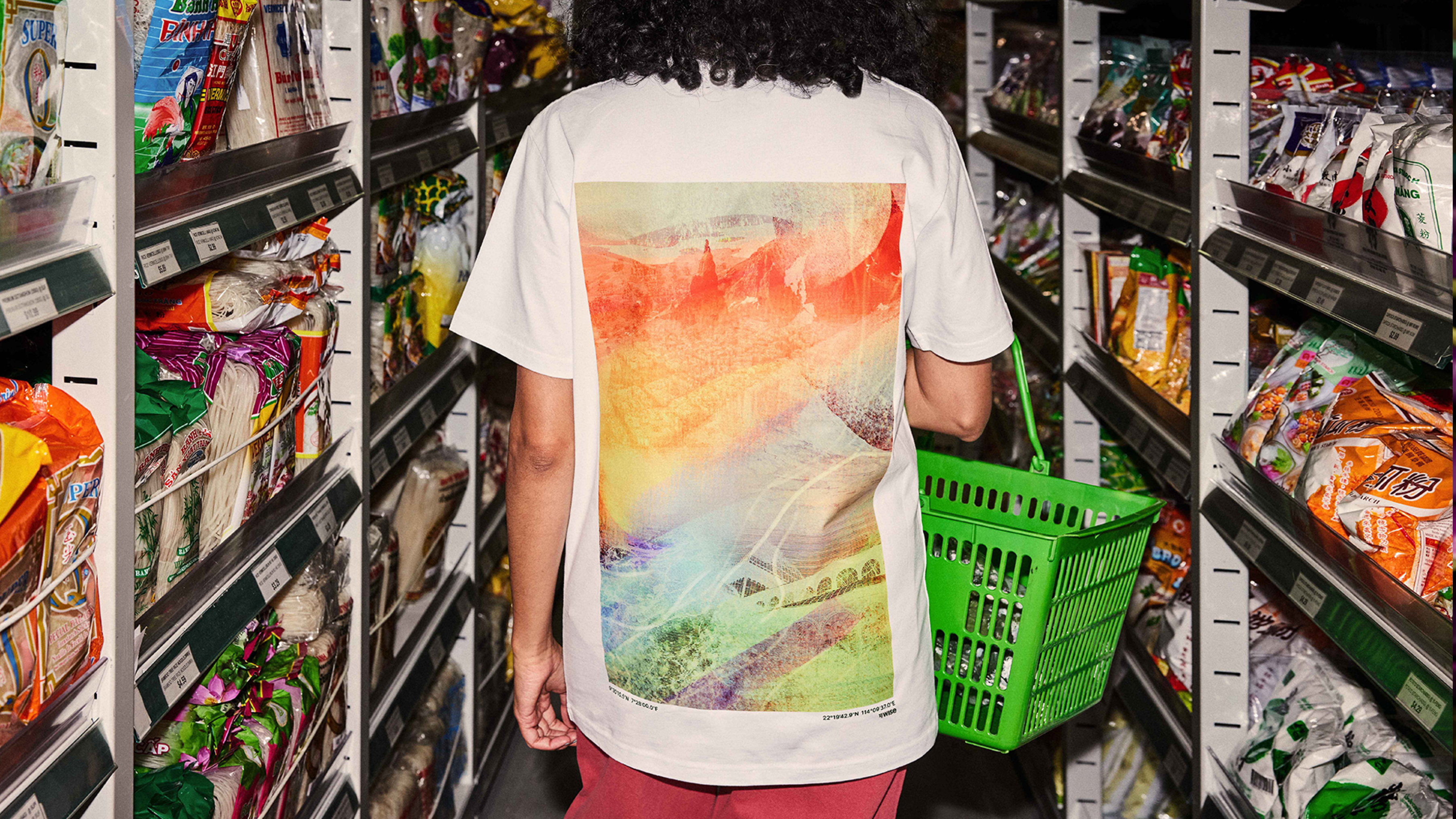 Person shopping in a grocery store wearing a shirt with a Wise tapestry