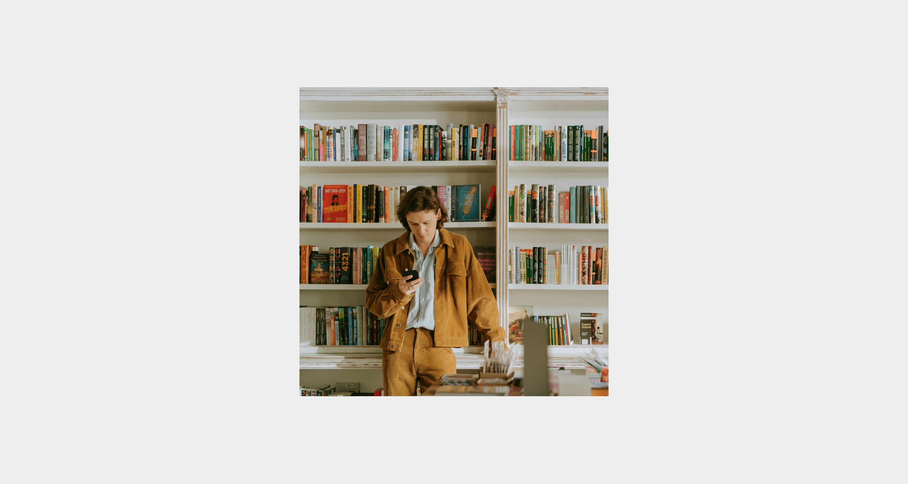 A man standing in his home looking at his phone